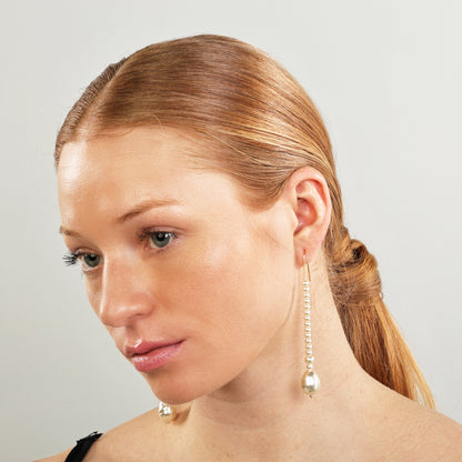 Long pearl earrings draw attention to the neckline and framing the face beautifully.