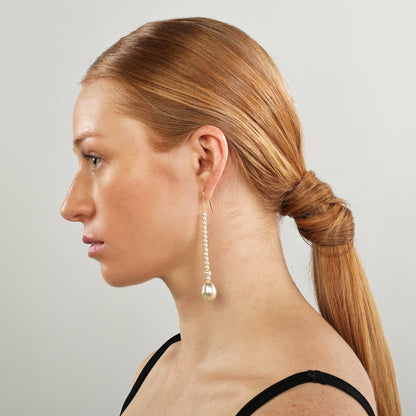 The elongated drop pearl earrings add drama and elegance.