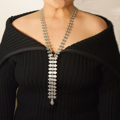 Model wearing long Storm Necklace with open-shoulder black top