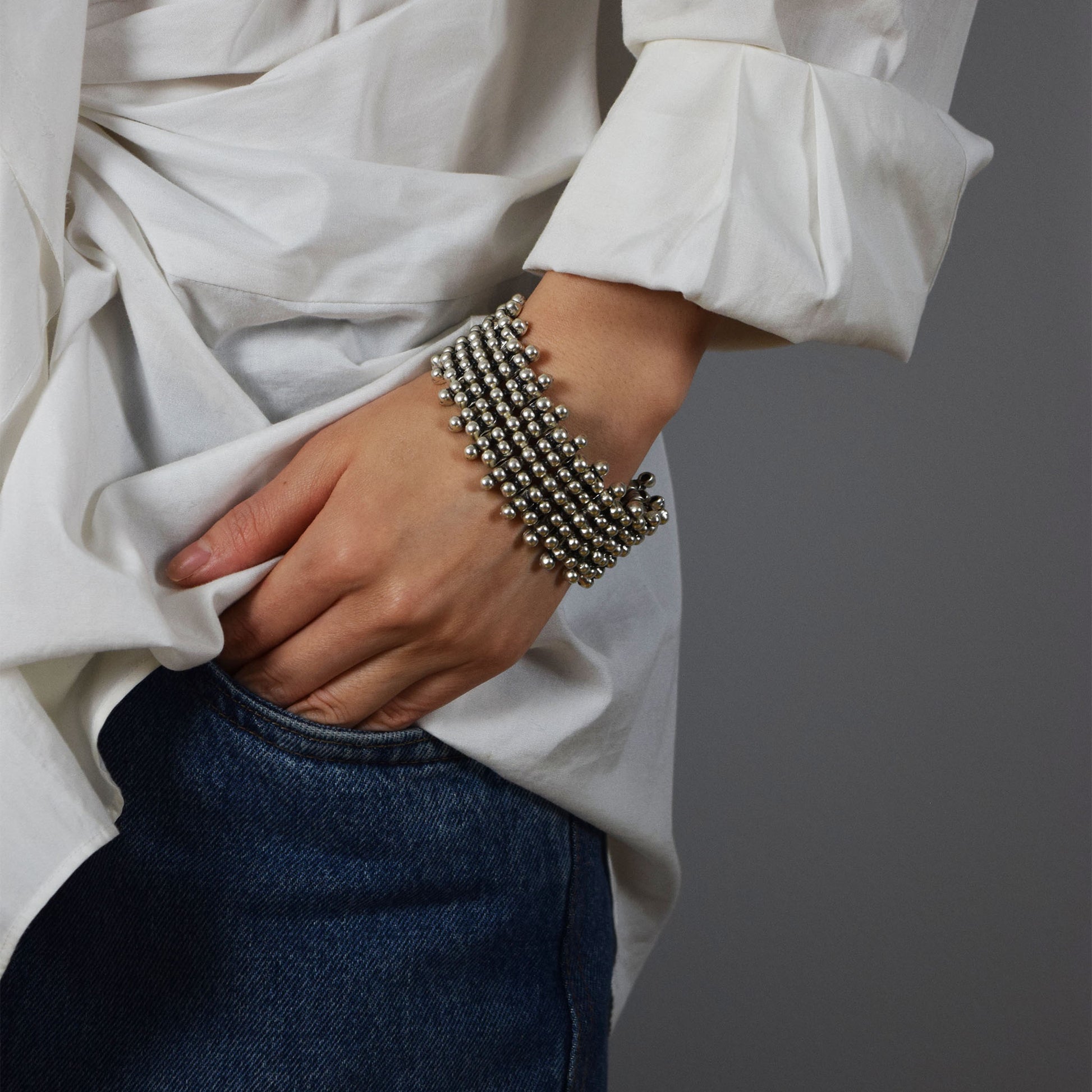Model wearing Wei Bracelet with oversized stylish white shirt and dark jeans